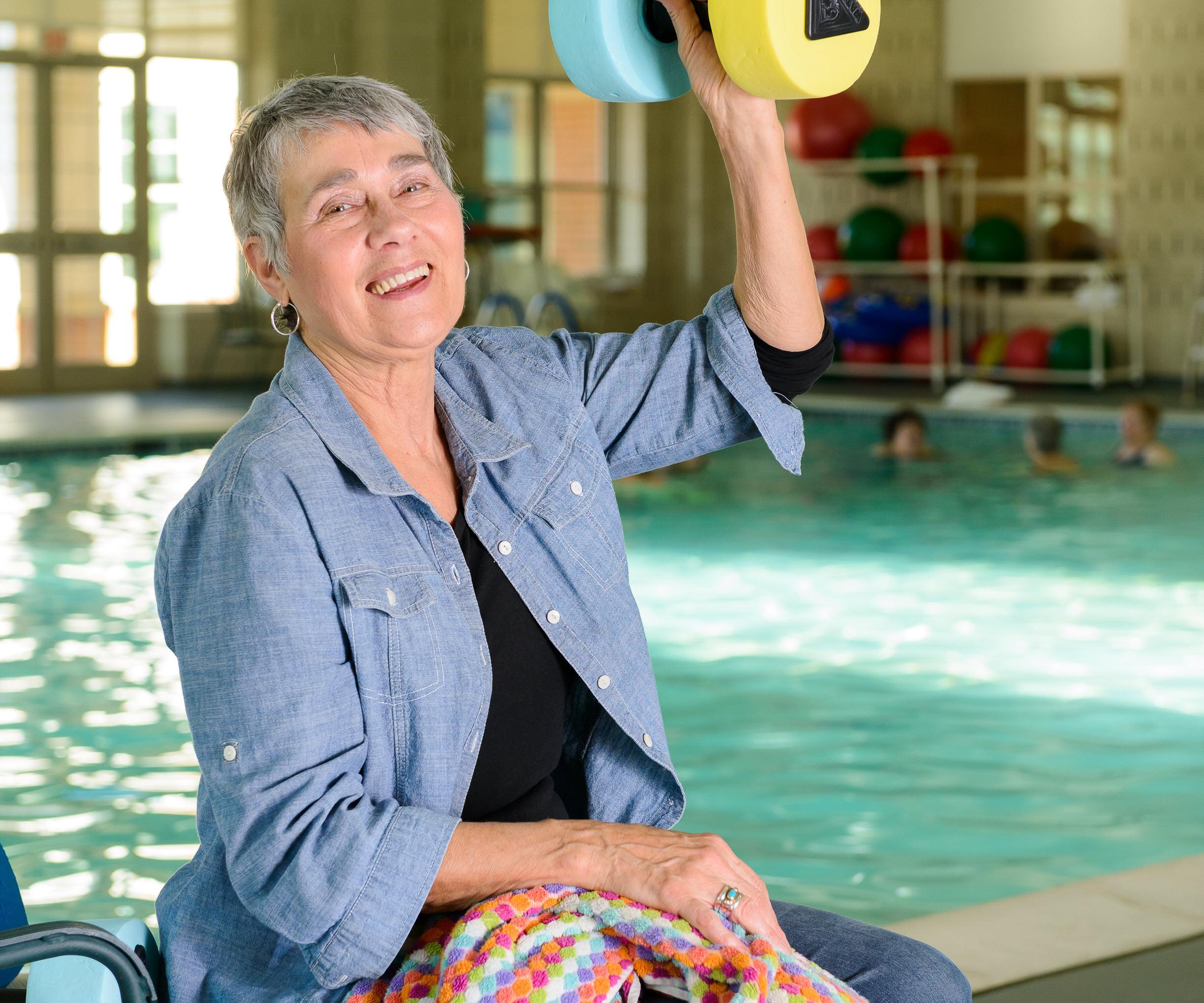 woman lifting pool weights at large pool