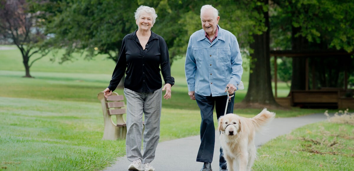 senior couple walking dog
