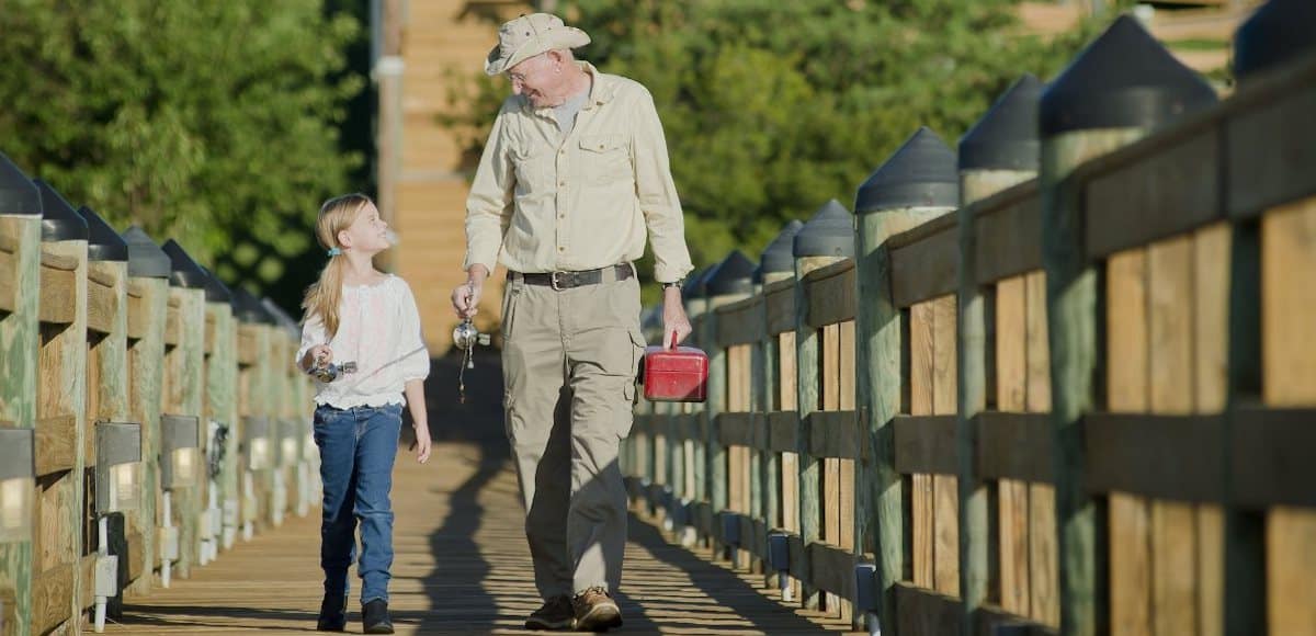 granddaughter and grandfather walking on dock