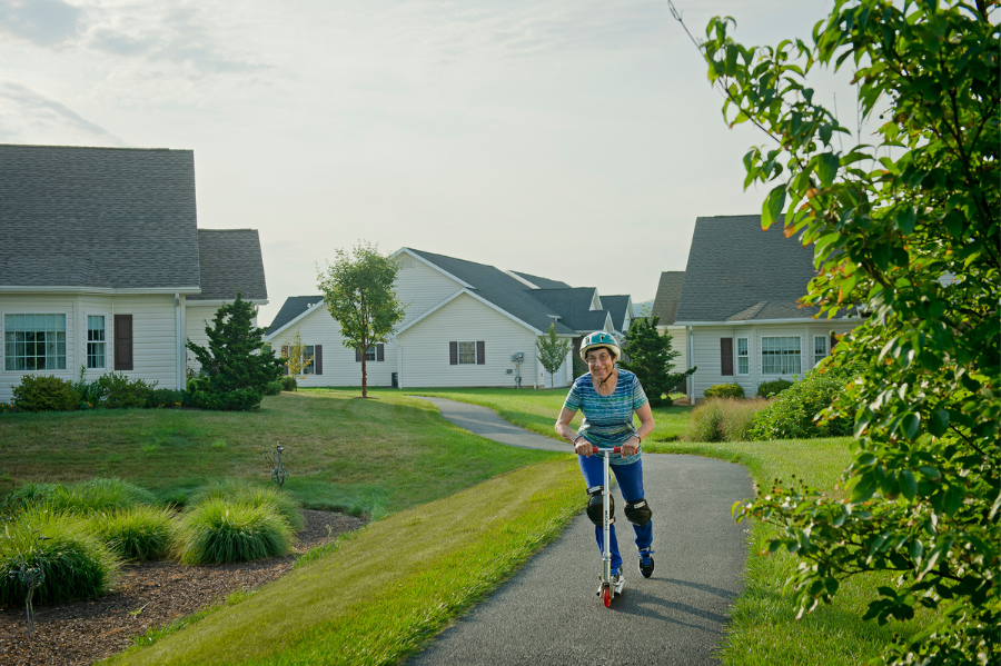 Woman riding a scooter on walking path