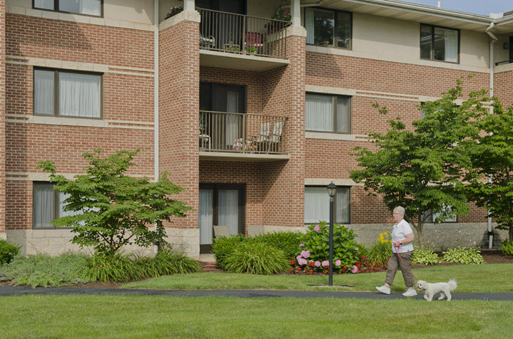 resident walking dog at Bethany Village court apartments