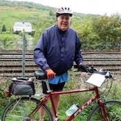 Lowell Starling, a 71 year old man outside standing next to his bike.