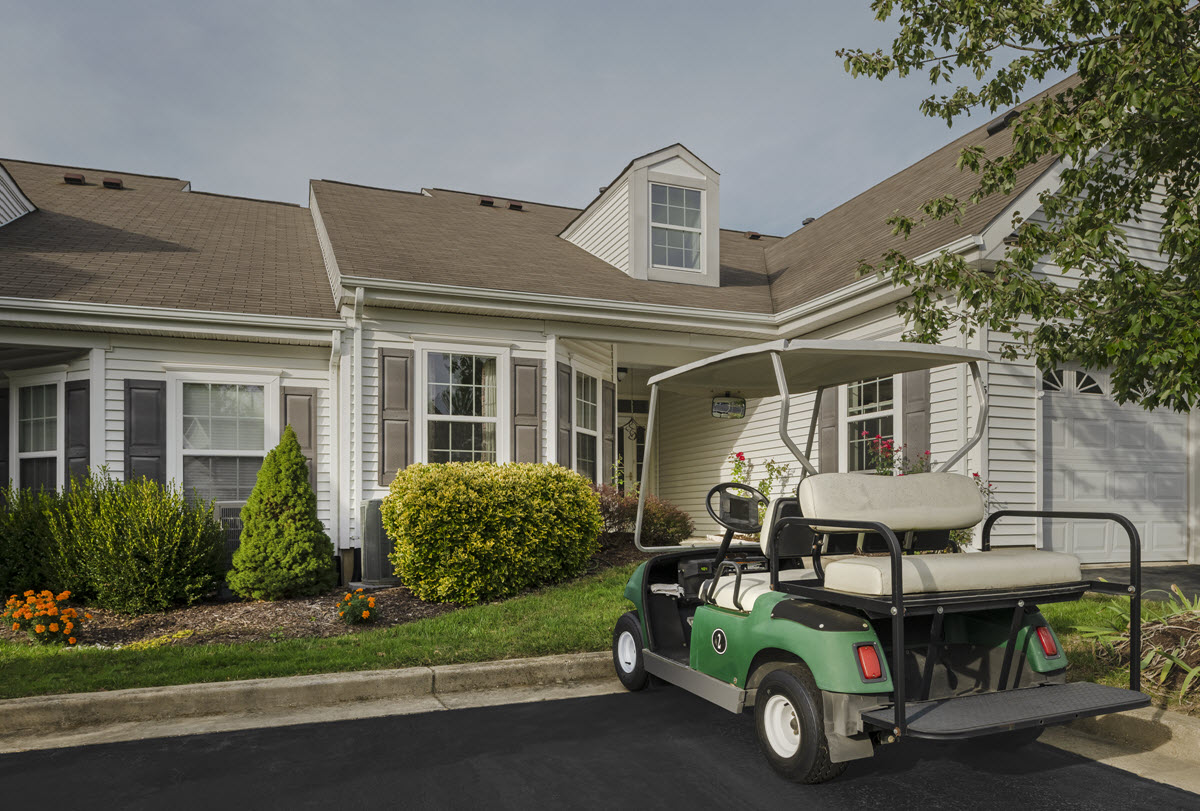 exterior view of cottage home with golf cart