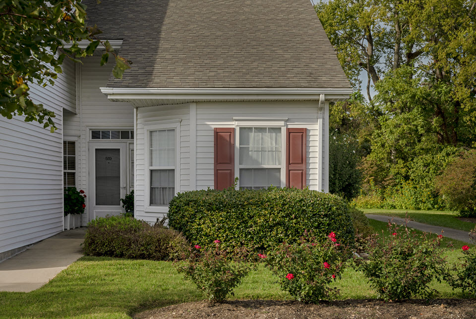 exterior view of cottage home with shrubs