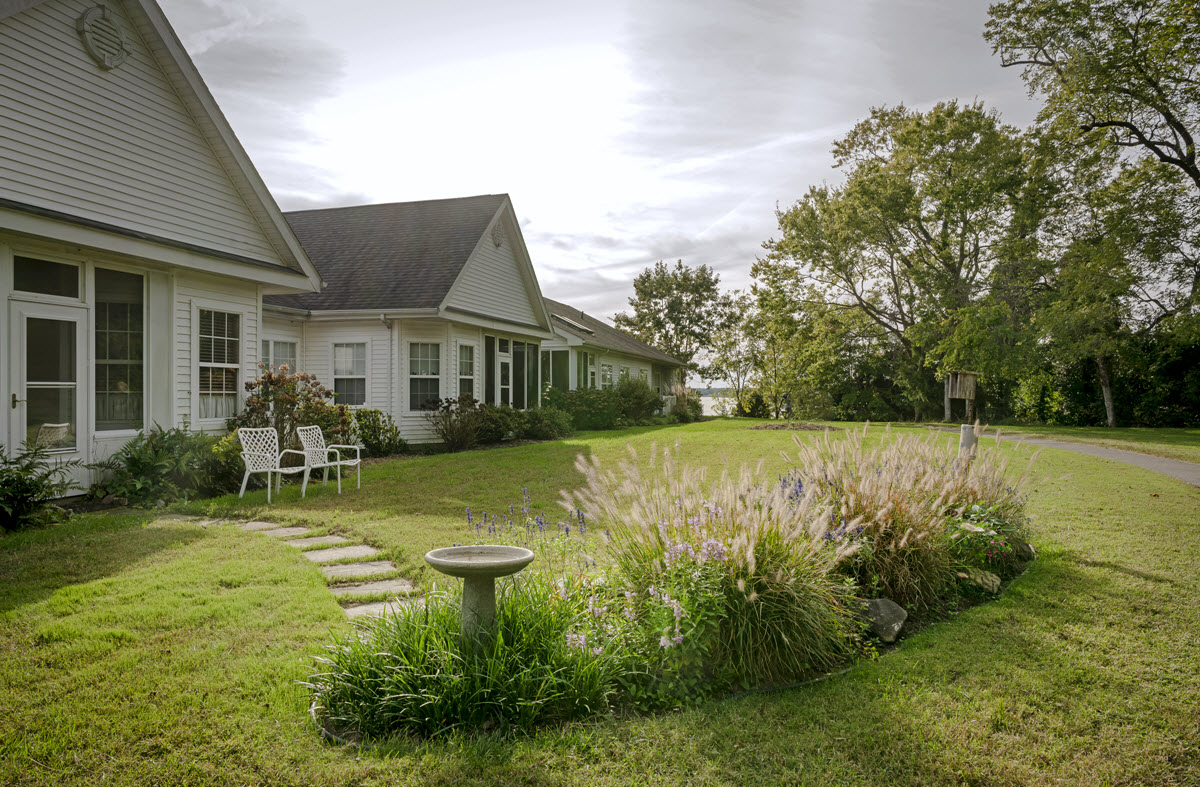 backyard exterior view of cottage home with birdfeeder and garden