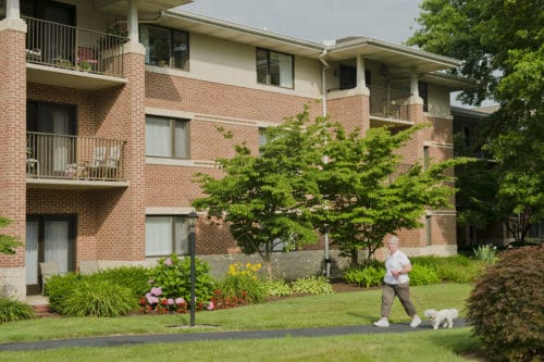 resident walking dog at bethany court apartments