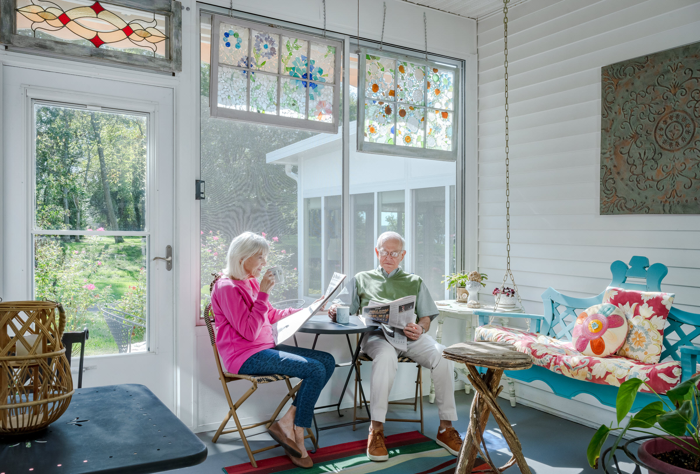 an older couple in their living room having breakfast and reading paper at the table