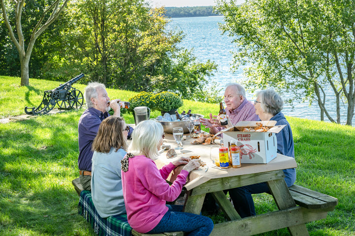 group of 5 older residents having a crab feast at picnic table