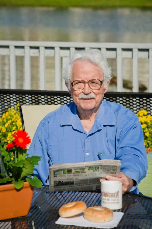 Resident reading and having coffee on the patio