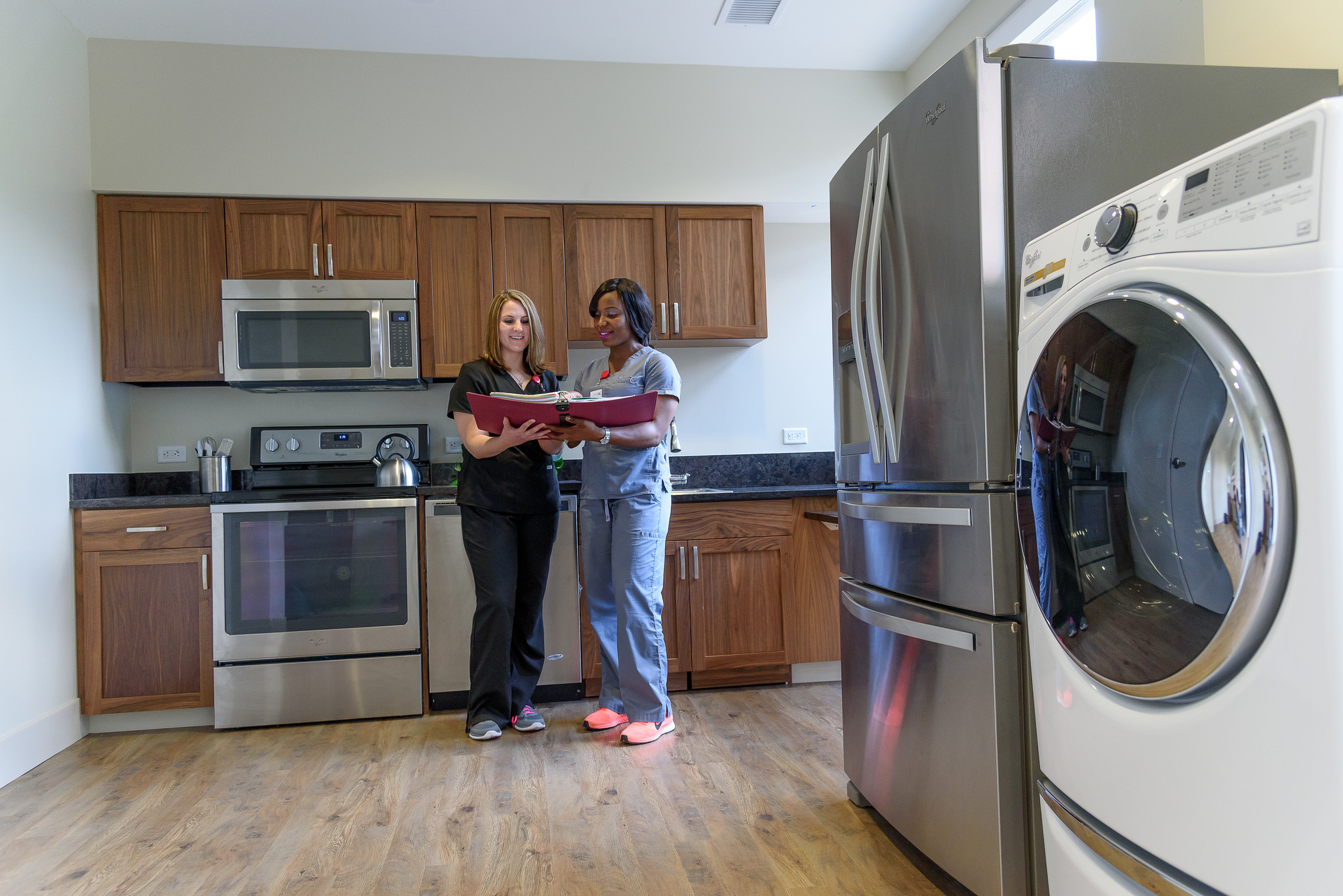 healthcare workers looking at a binder in a senior apartment