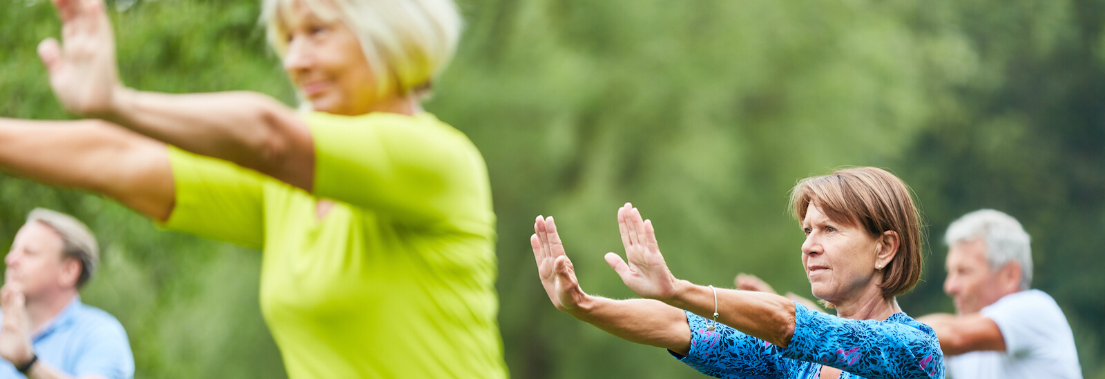 A group of healthy women and men exercising outside and breathing in fresh air.