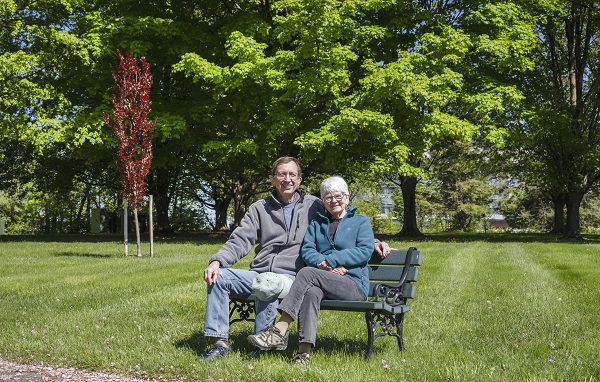 resident couple sitting on a bench enjoying the sun