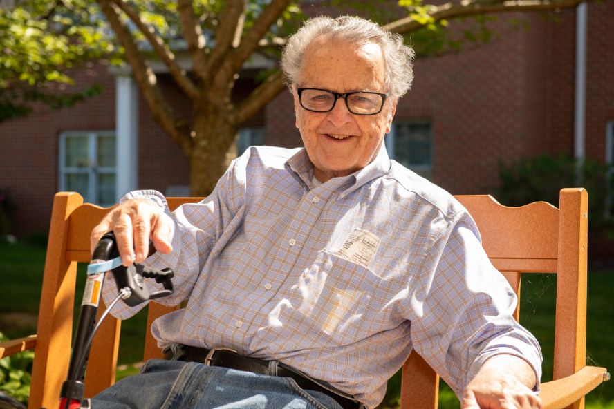 resident enjoying the outdoors on a bench at Normandie Ridge