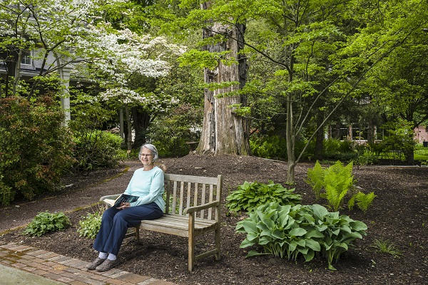 resident relaxing on a bench on the paths of riverwoods