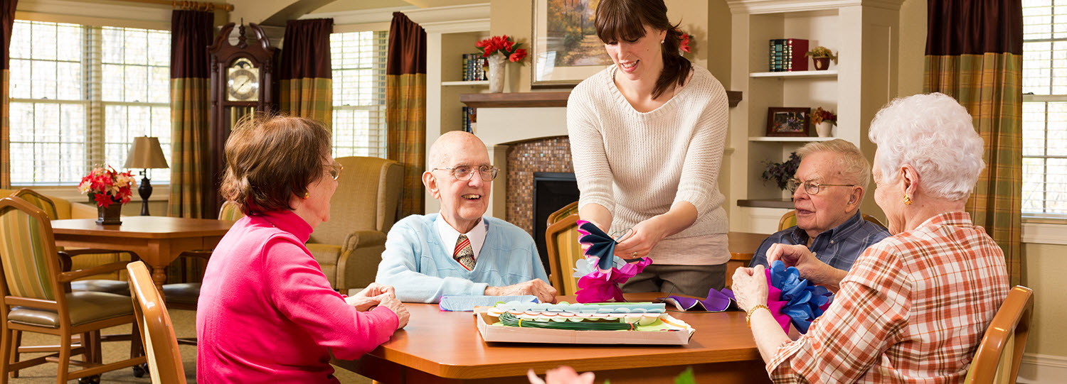 residents making decorations with staff member