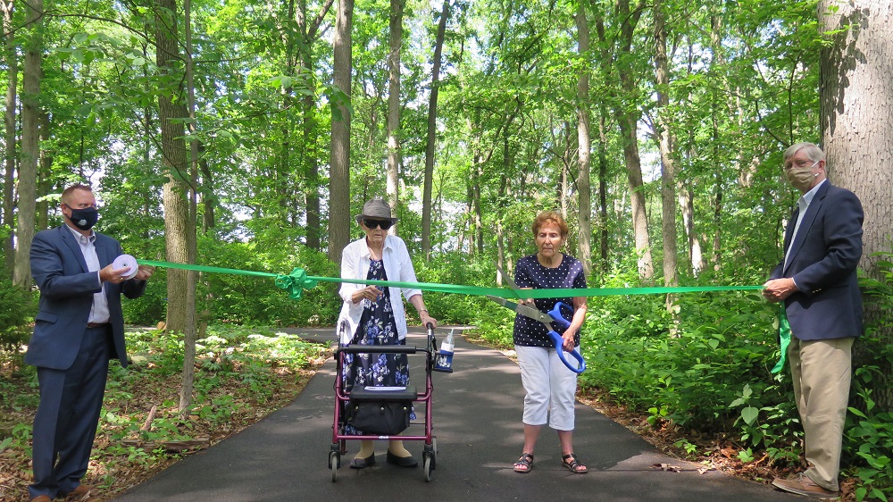 residents cutting ribbon during dedication of happy trails nature park