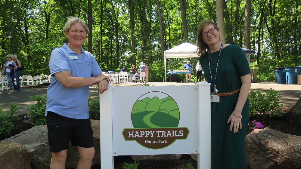 residents standing by sign for happy trail nature park