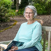 resident sitting on a bench in garden reading