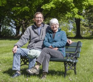 RiverWoods couple sitting on bench near campus walking path