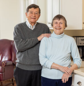 Diane and Ed Myers leaning on counter of open kitchen in cottage