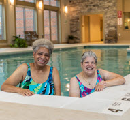 Two women smile in Springhill pool