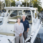 married couple stand in boat at Solomons Island marina