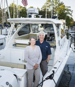 married couple stand in boat at Solomons Island marina