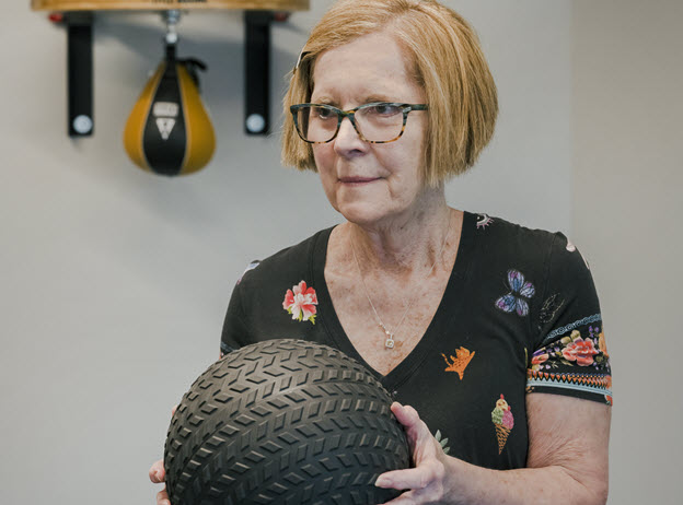 woman lifts medicine ball