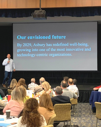 Doug Leidig on stage with envisioned future statement behind him