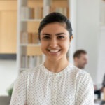 young woman smiling in office as she starts internship