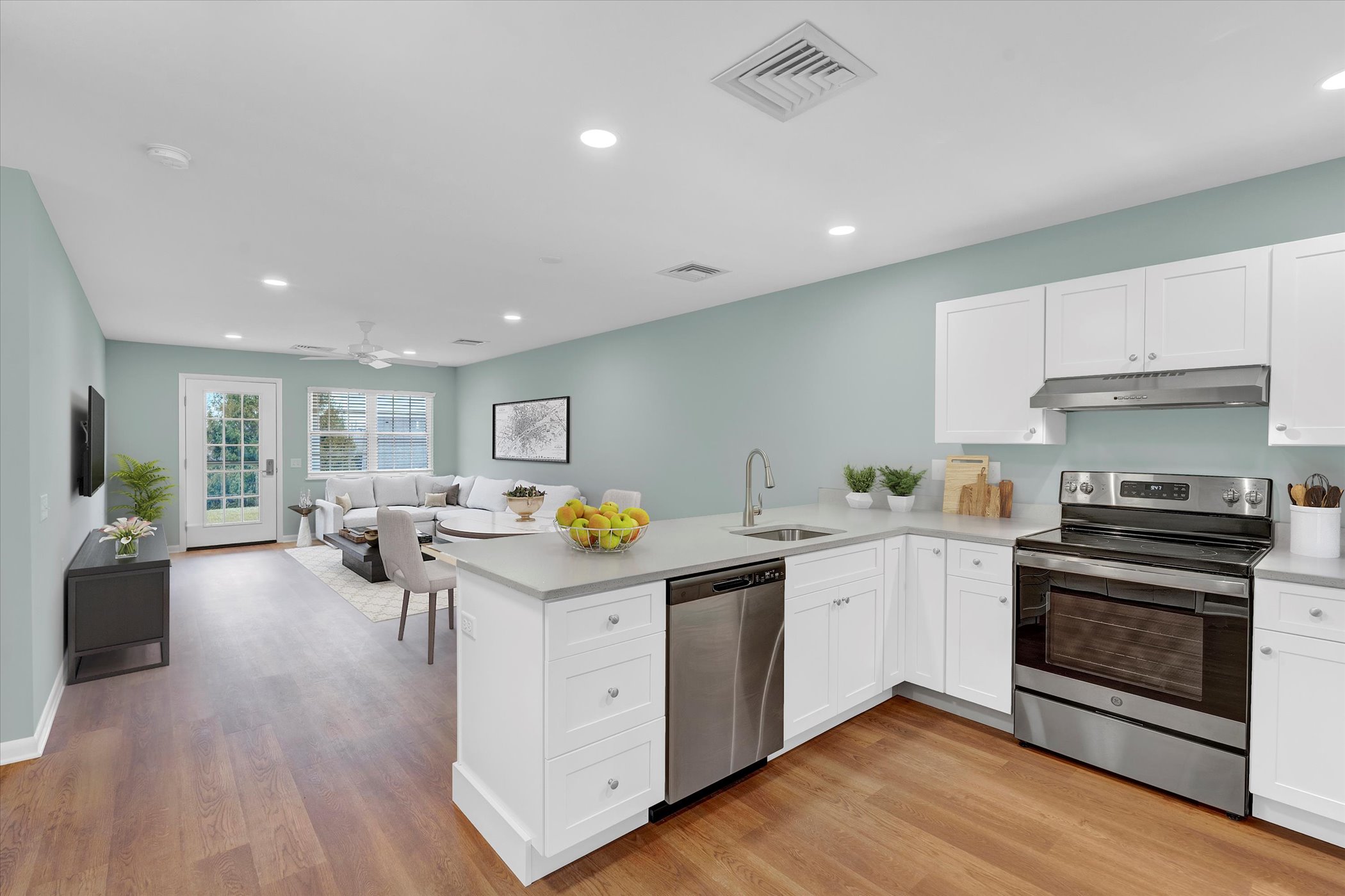 open kitchen with counter for dining looking out onto bright, open living room