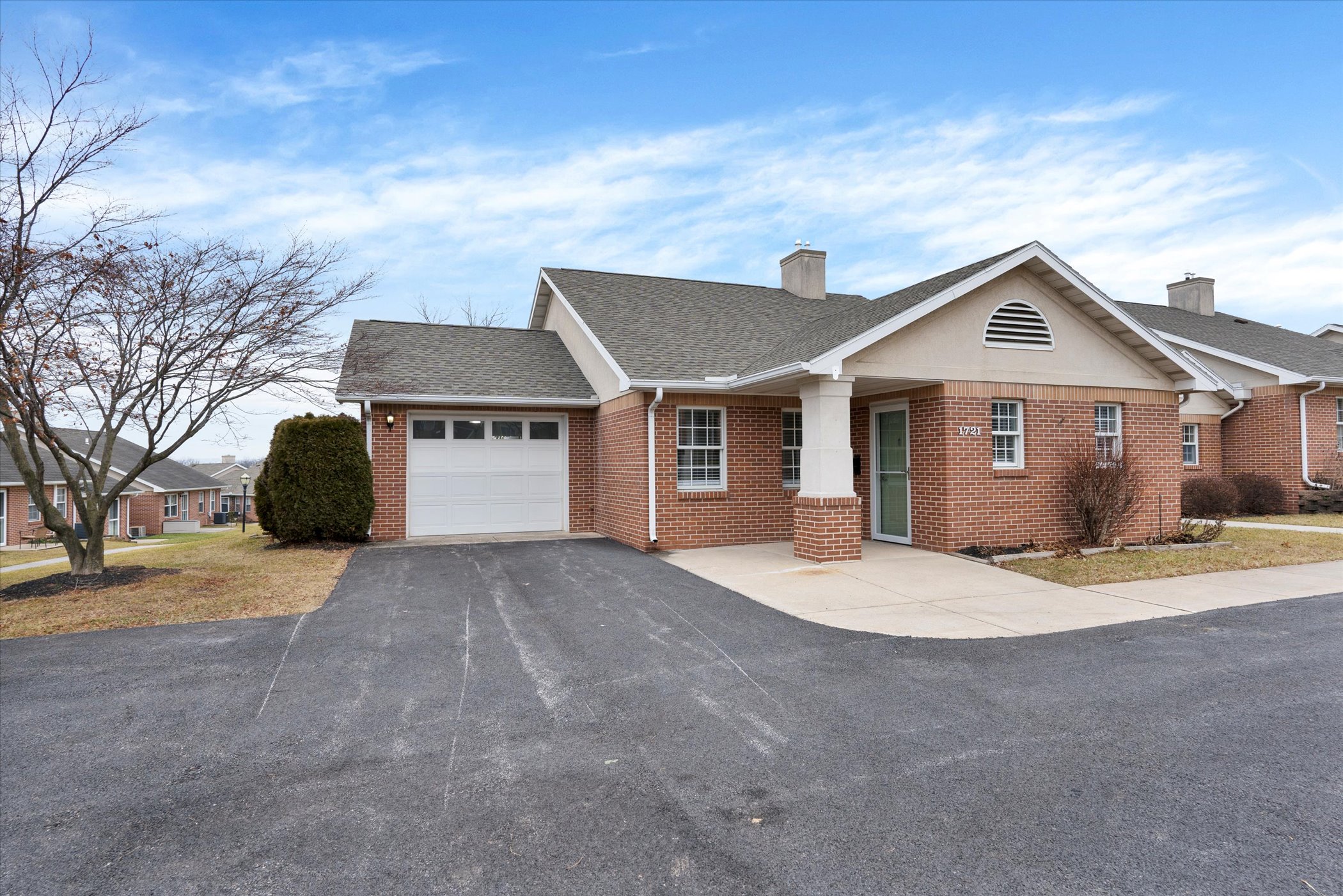 brick cottage entrance with driveway and garage