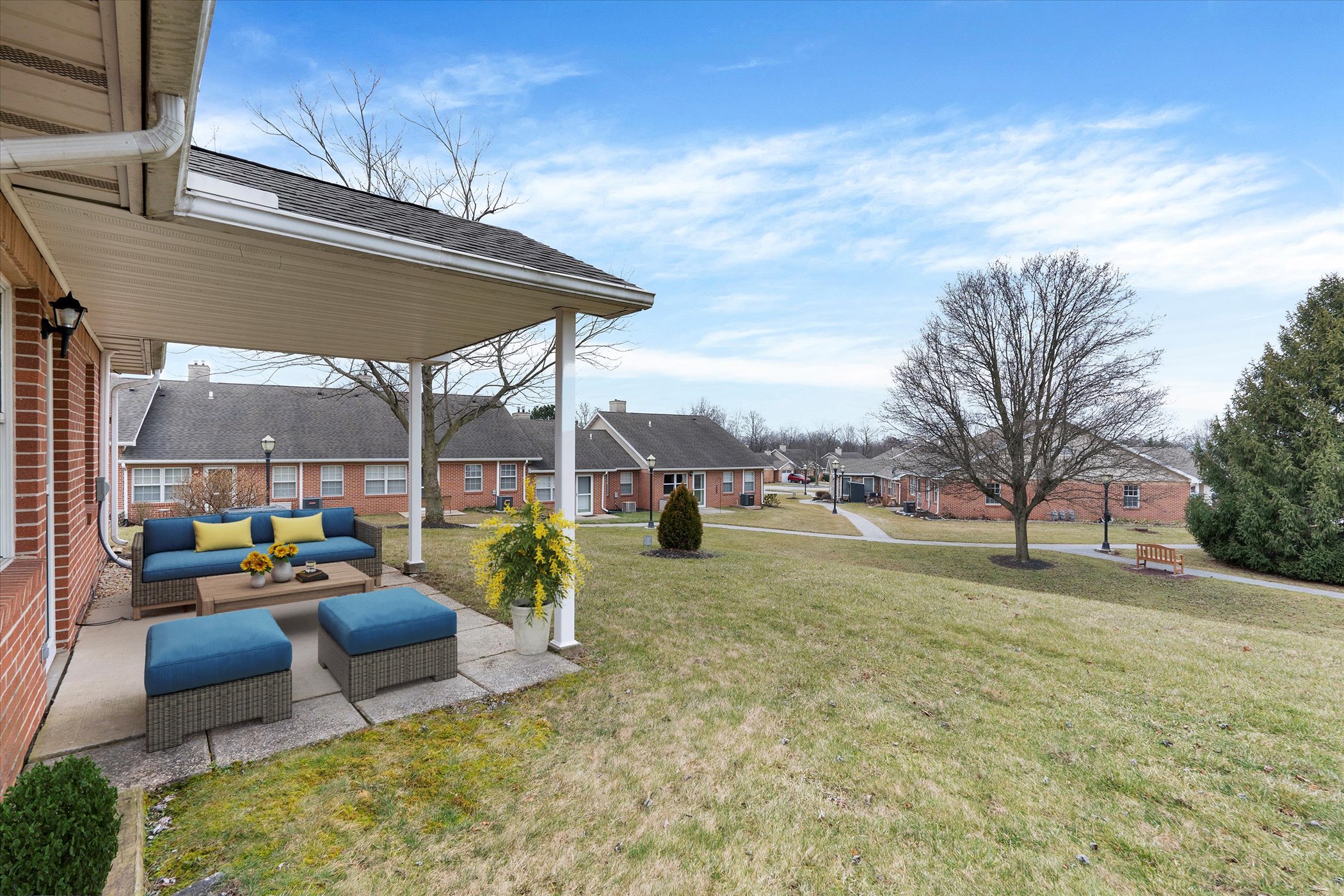 rear of brick cottage with patio, patio furniture and lawn