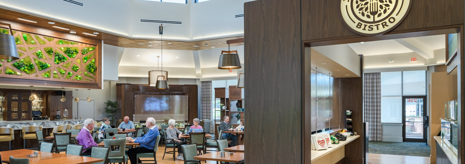 large bistro with bar in background and five tables of diners