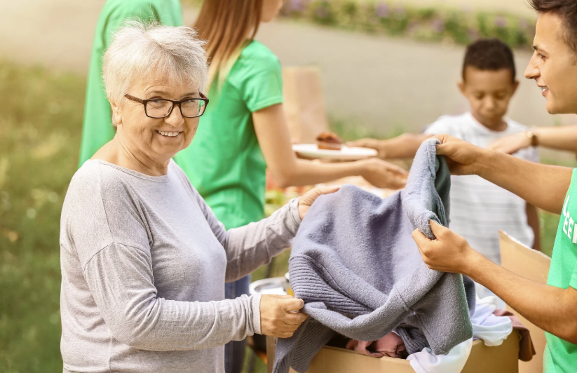 senior donating clothes with youth