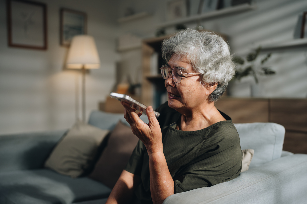 Senior woman using an AI-powered app on her smartphone to enhance her online language lesson. With a focused expression, she engages in interactive exercises and pronunciation practice, making the most of modern technology to support her learning journey and build her language skills